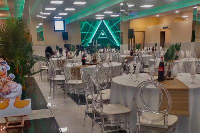 Cuisine professionnelle équipée avec lave-vaisselle industriel, réfrigérateur, plan de travail et cuisinière en inox.