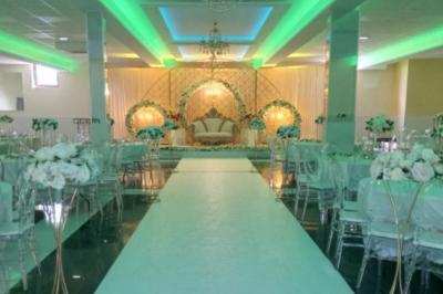 Cuisine professionnelle équipée avec lave-vaisselle industriel, réfrigérateur, plan de travail et cuisinière en inox.