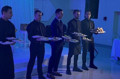 Cuisine professionnelle équipée avec lave-vaisselle industriel, réfrigérateur, plan de travail et cuisinière en inox.