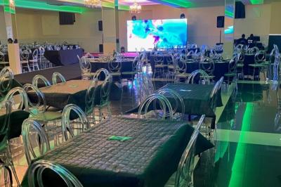 Cuisine professionnelle équipée avec lave-vaisselle industriel, réfrigérateur, plan de travail et cuisinière en inox.