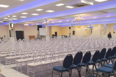 Cuisine professionnelle équipée avec lave-vaisselle industriel, réfrigérateur, plan de travail et cuisinière en inox.