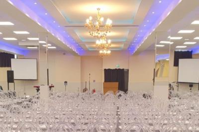 Cuisine professionnelle équipée avec lave-vaisselle industriel, réfrigérateur, plan de travail et cuisinière en inox.