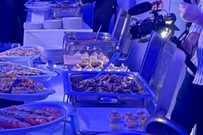 Cuisine professionnelle équipée avec lave-vaisselle industriel, réfrigérateur, plan de travail et cuisinière en inox.