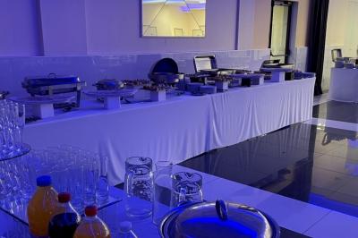 Cuisine professionnelle équipée avec lave-vaisselle industriel, réfrigérateur, plan de travail et cuisinière en inox.