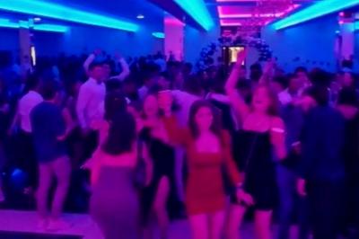 Cuisine professionnelle équipée avec lave-vaisselle industriel, réfrigérateur, plan de travail et cuisinière en inox.