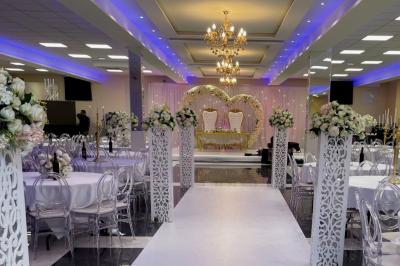 Cuisine professionnelle équipée avec lave-vaisselle industriel, réfrigérateur, plan de travail et cuisinière en inox.