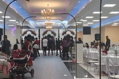 Cuisine professionnelle équipée avec lave-vaisselle industriel, réfrigérateur, plan de travail et cuisinière en inox.