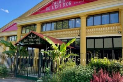 Cuisine professionnelle équipée avec lave-vaisselle industriel, réfrigérateur, plan de travail et cuisinière en inox.