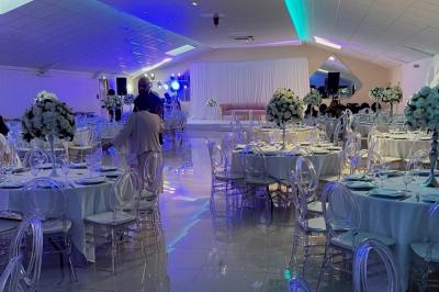 Cuisine professionnelle équipée avec lave-vaisselle industriel, réfrigérateur, plan de travail et cuisinière en inox.