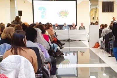 Cuisine professionnelle équipée avec lave-vaisselle industriel, réfrigérateur, plan de travail et cuisinière en inox.