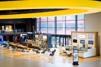 Salle de cinéma avec sièges rouges vides et grand écran affichant le logo IMAX.