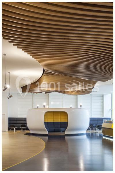 Espace intérieur moderne avec plafond en bois ondulé, alcôve blanche arrondie et sièges intégrés.