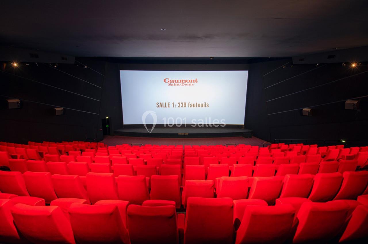 Salle de cinéma avec des rangées de fauteuils rouges vides et un écran affichant ’Salle : 339 fauteuils’.