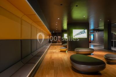 Salle de cinéma vide avec sièges inclinables 4DX, éclairage tamisé et projecteurs suspendus au plafond.