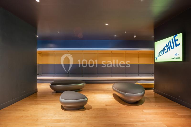 Espace intérieur moderne avec bancs design, sol en bois clair et panneau lumineux affichant ’Bienvenue’.