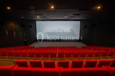 Salle de cinéma vide avec sièges inclinables 4DX, éclairage tamisé et projecteurs suspendus au plafond.