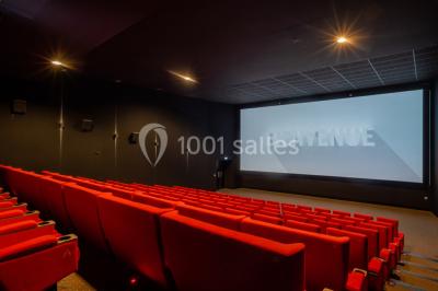 Salle de cinéma vide avec sièges inclinables 4DX, éclairage tamisé et projecteurs suspendus au plafond.