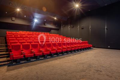 Salle de cinéma vide avec sièges inclinables 4DX, éclairage tamisé et projecteurs suspendus au plafond.