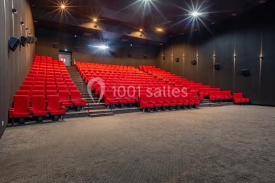 Salle de cinéma vide avec sièges inclinables 4DX, éclairage tamisé et projecteurs suspendus au plafond.
