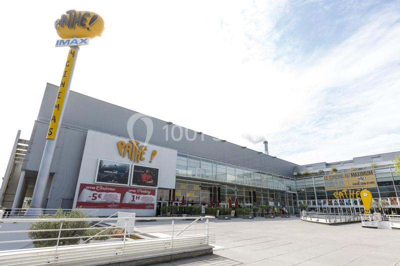 Façade d'un cinéma Pathé avec enseigne IMAX, affiches de films et entrée principale entourée de vitrages.