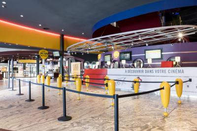 Façade d'un cinéma Pathé avec enseigne IMAX, affiches de films et entrée principale entourée de vitrages.