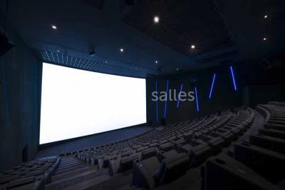 Façade d'un bâtiment moderne avec des enseignes de cinéma IMAX et 4DX, entouré d'une pelouse et d'arbustes.