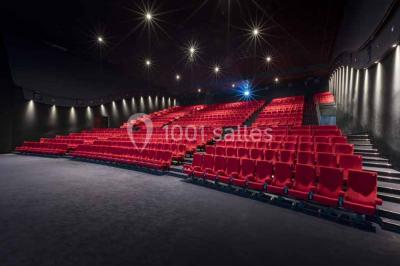 Façade d'un bâtiment moderne avec des enseignes de cinéma IMAX et 4DX, entouré d'une pelouse et d'arbustes.