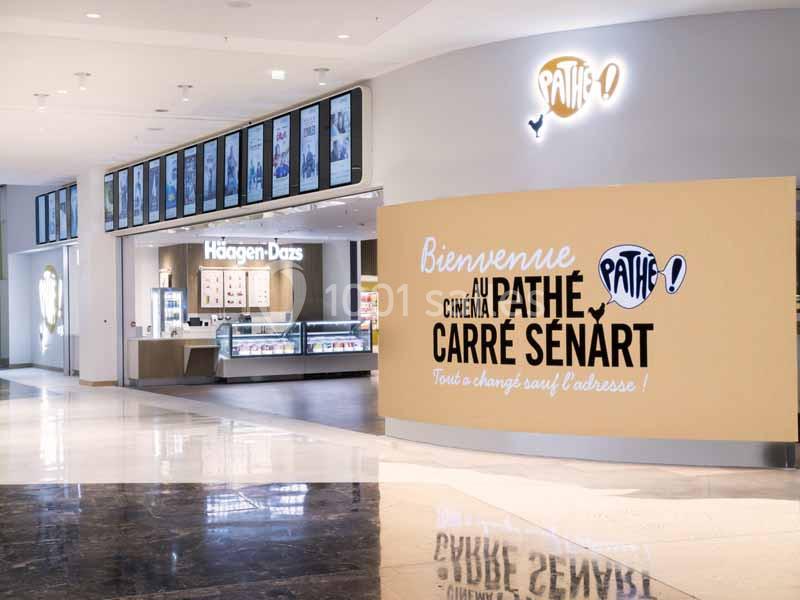 Entrée d'un cinéma Pathé au Carré Sénart avec un mur d'accueil et un stand Häagen-Dazs à proximité.
