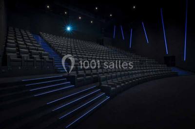 Façade d'un bâtiment moderne avec des enseignes de cinéma IMAX et 4DX, entouré d'une pelouse et d'arbustes.