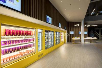 Façade d'un bâtiment moderne avec des enseignes de cinéma IMAX et 4DX, entouré d'une pelouse et d'arbustes.