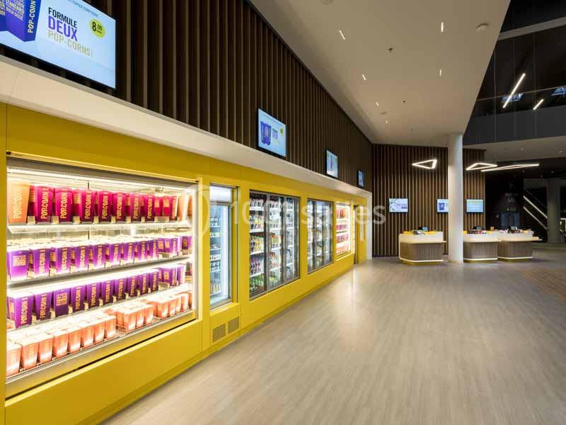 Rayons réfrigérés avec boissons et produits alimentaires dans un espace moderne et lumineux.