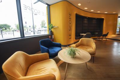 Salle de cinéma vide avec des rangées de sièges rouges et un éclairage tamisé sur les murs.