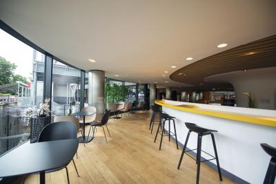 Salle de cinéma vide avec des rangées de sièges rouges et un éclairage tamisé sur les murs.