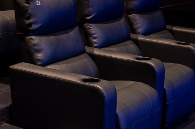 Vue intérieure d'un espace moderne avec escalier, escalator rouge et murs sombres décorés de motifs colorés.