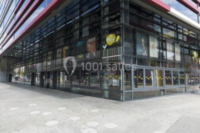 Salle de cinéma vide avec des rangées de sièges rouges et un éclairage tamisé.