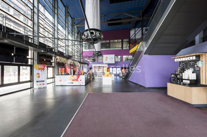 Hall spacieux avec comptoirs de restauration rapide, distributeurs automatiques et escalier menant à un étage supérieur.