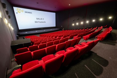Vue intérieure d'un hall lumineux avec des stands colorés, des escaliers roulants et de grandes baies vitrées.