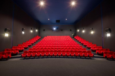 Vue intérieure d'un hall lumineux avec des stands colorés, des escaliers roulants et de grandes baies vitrées.
