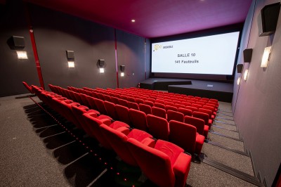 Vue intérieure d'un hall lumineux avec des stands colorés, des escaliers roulants et de grandes baies vitrées.