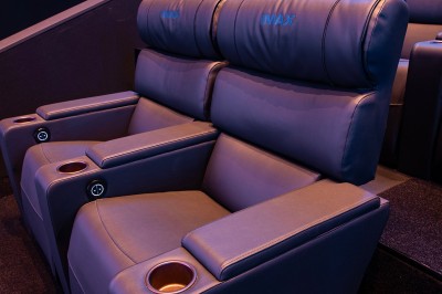 Vue intérieure d'un hall lumineux avec des stands colorés, des escaliers roulants et de grandes baies vitrées.