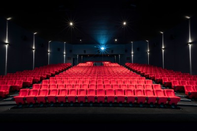 Salle de cinéma équipée de sièges 4DX avec écran lumineux affichant le logo 4DX, éclairage tamisé.