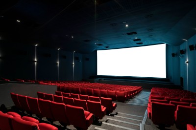 Salle de cinéma équipée de sièges 4DX avec écran lumineux affichant le logo 4DX, éclairage tamisé.