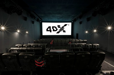 Salle de cinéma équipée de sièges 4DX avec écran lumineux affichant le logo 4DX, éclairage tamisé.