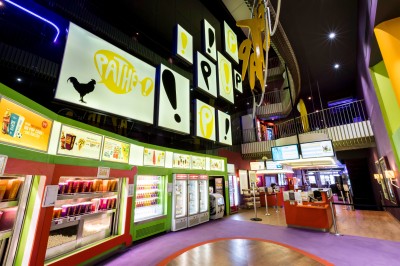 Salle de cinéma équipée de sièges 4DX avec écran lumineux affichant le logo 4DX, éclairage tamisé.