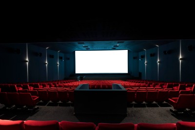 Salle de cinéma équipée de sièges 4DX avec écran lumineux affichant le logo 4DX, éclairage tamisé.