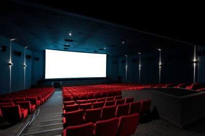 Salle de cinéma équipée de sièges 4DX avec écran lumineux affichant le logo 4DX, éclairage tamisé.