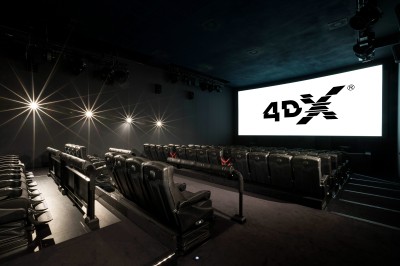 Salle de cinéma équipée de sièges 4DX avec écran lumineux affichant le logo 4DX, éclairage tamisé.