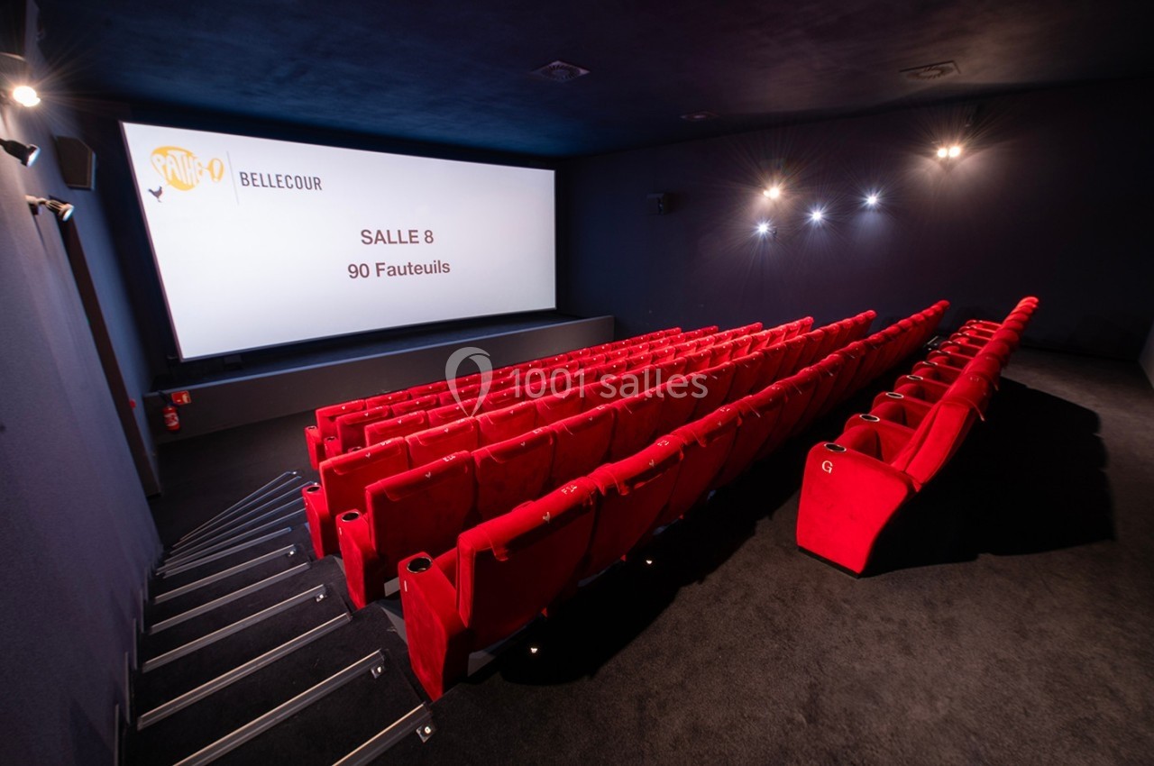Salle de cinéma avec des rangées de fauteuils rouges et un écran affichant ’Salle 8, 90 fauteuils’.