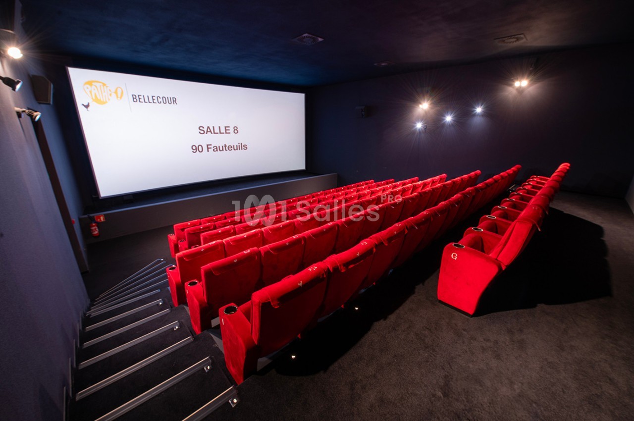 Salle de cinéma avec des rangées de fauteuils rouges et un écran affichant ’Salle 8, 90 fauteuils’.