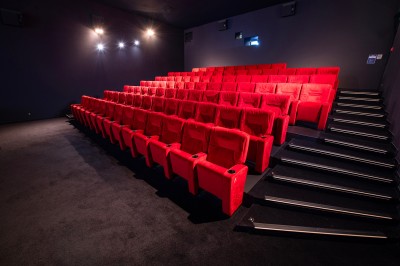 Salle de cinéma avec des rangées de fauteuils rouges et un écran affichant ’Salle 1, 318 fauteuils’.